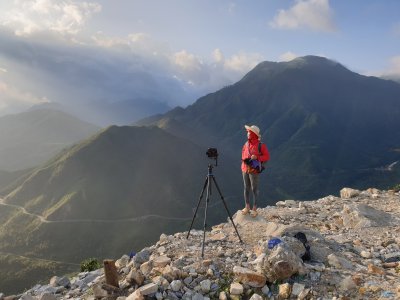 picture of hiker atop ridge with camera mounted on tripod