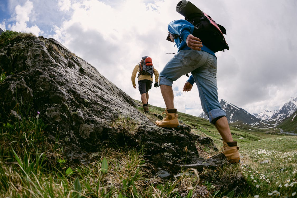 Hikers climbing a rocky mountain trail with backpacks.