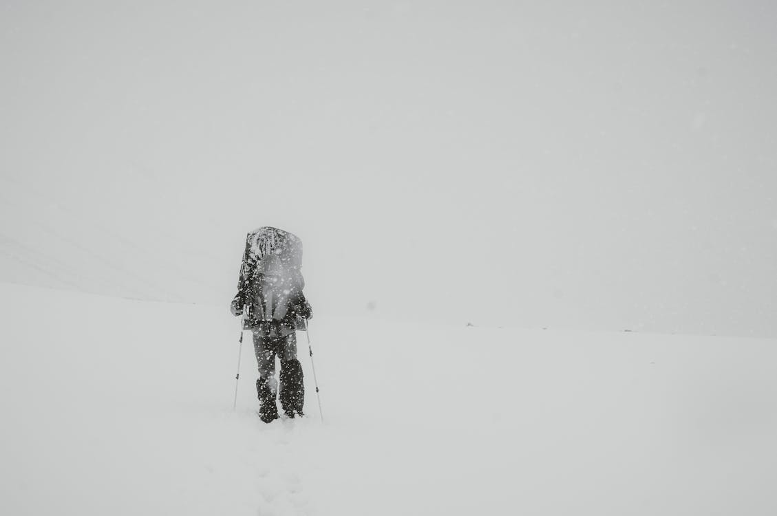 Hiker carrying a durable ski mountaineering pack while moving through heavy snow and winter mountain conditions.