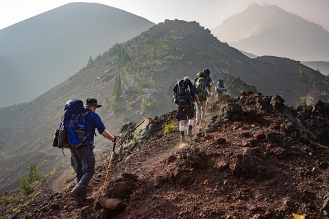 hikers with backpacks hiking on a mountain.