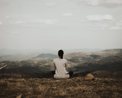 a person sitting on top of a mountain.
