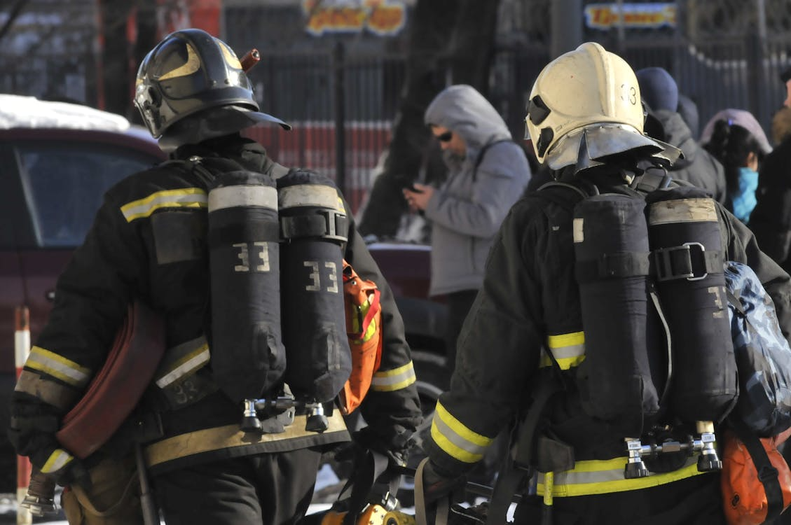 First responders carrying professional rescue gear during an emergency operation with heavy-duty equipment.