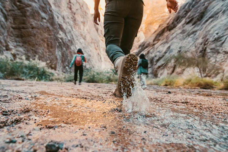 people walking on a muddy trail