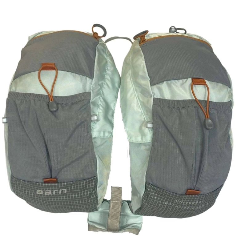 Universal balance bags worn on the front of a backpack for improved hiking balance and comfort